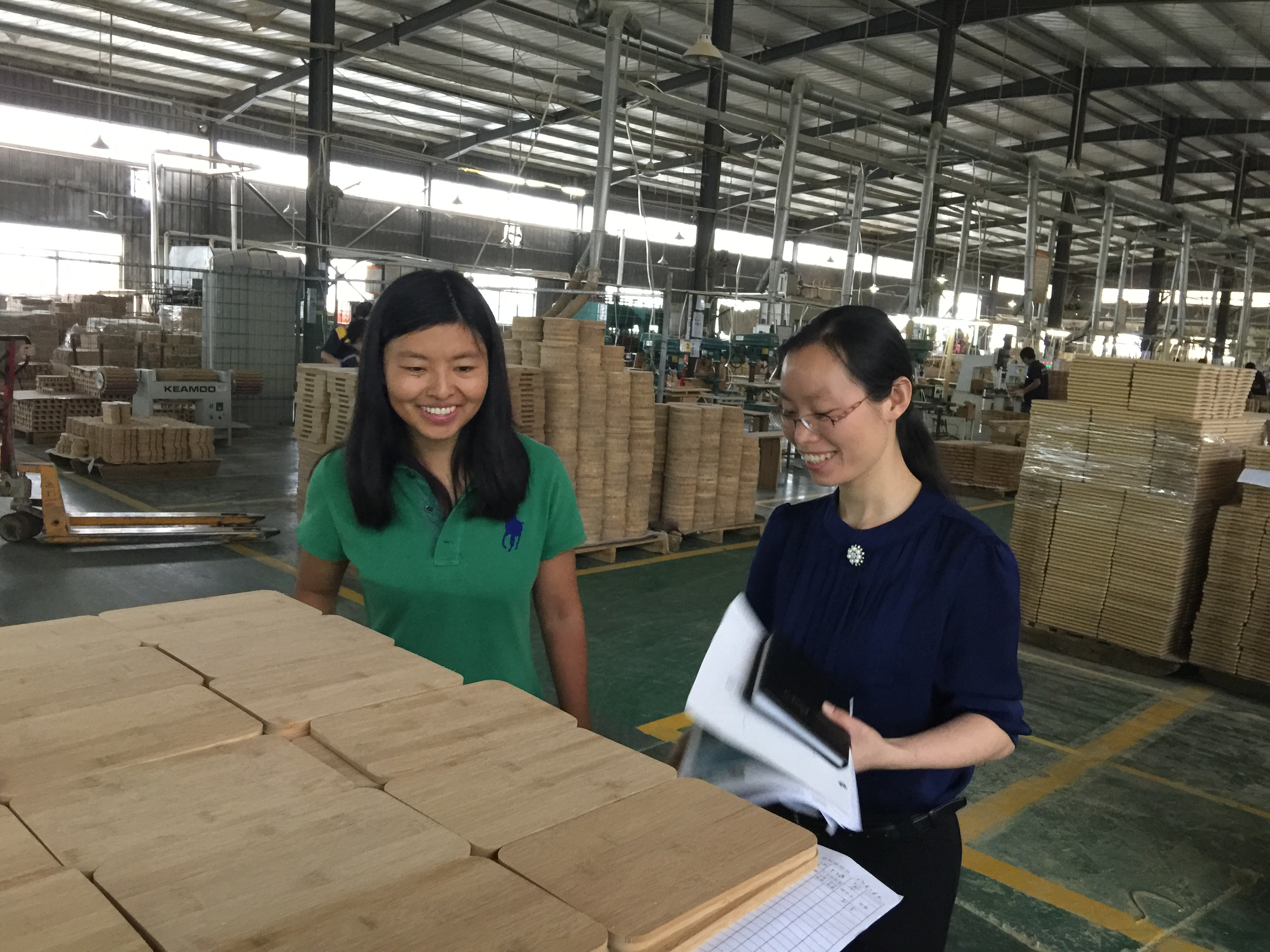 Mitarbeiterinnen prüfen verpackte Holzwaren in einem chinesischen Betrieb — Sendungen aus der Produktion unterliegen seit Juli 2026 neuen Zollregeln
