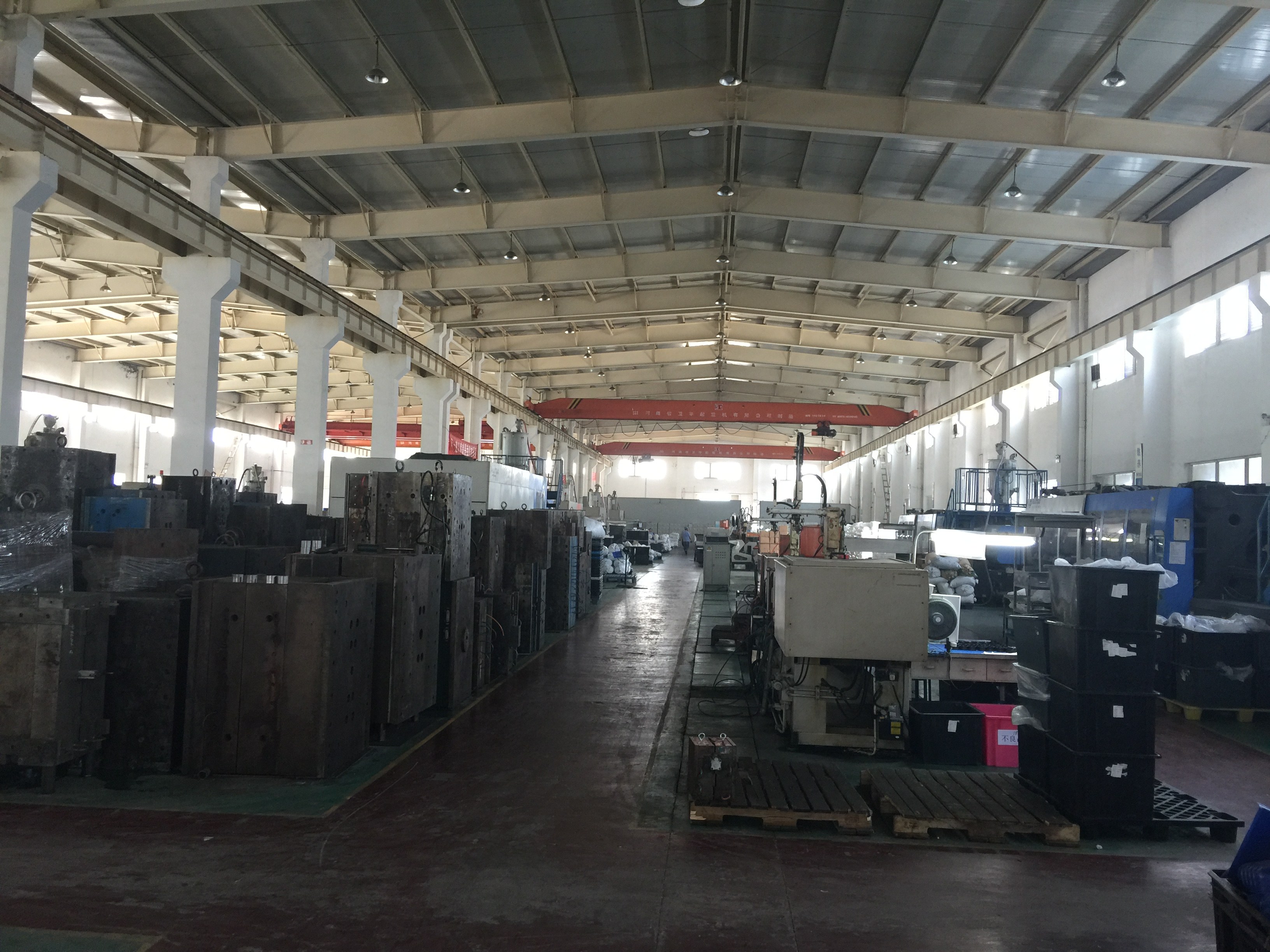Produktionshalle mit Maschinen, Formen und rotem Hallenkran
