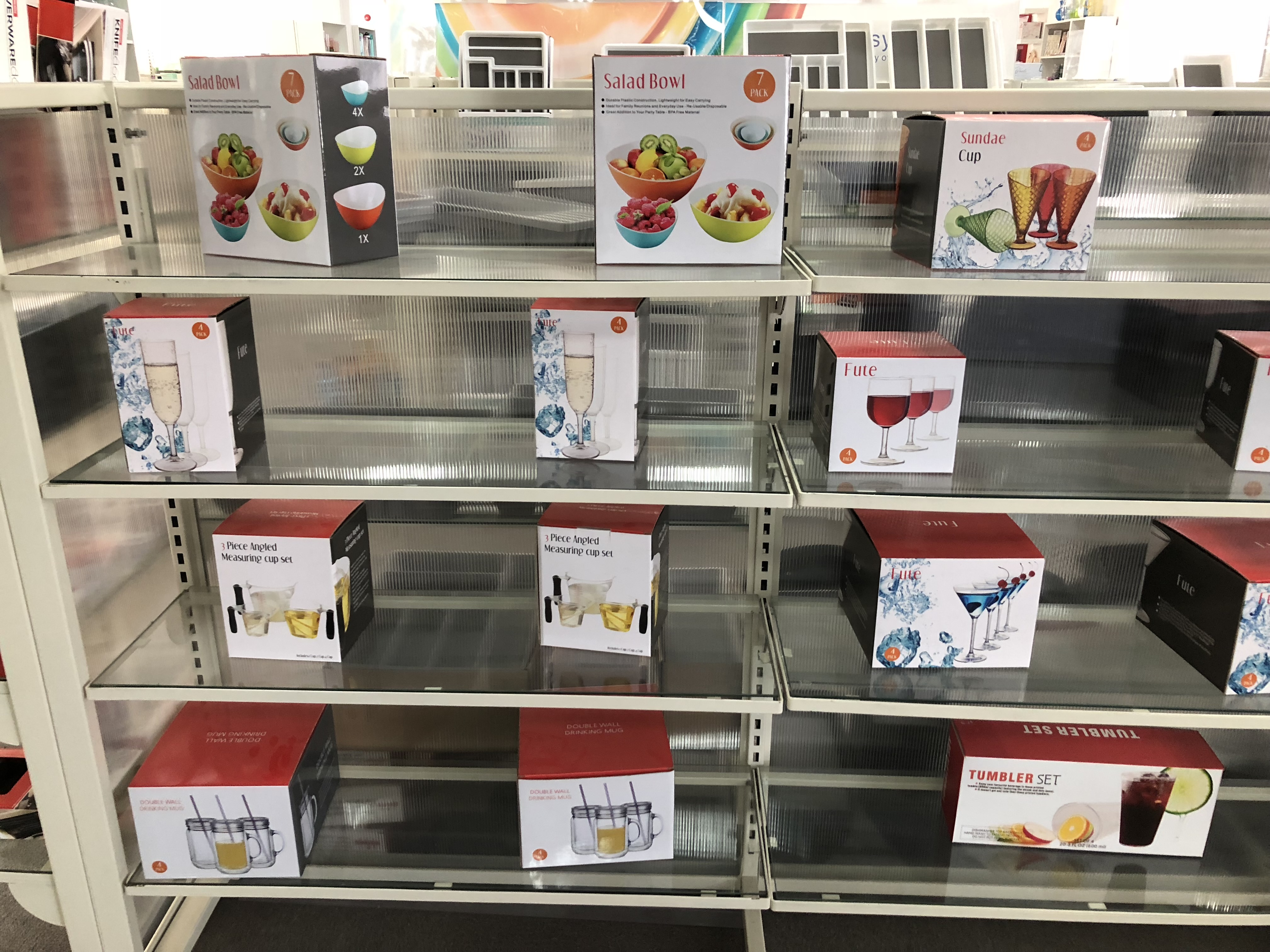 Verpackte Trinkgläser und Schüsselsets in Kartons auf einem Regal